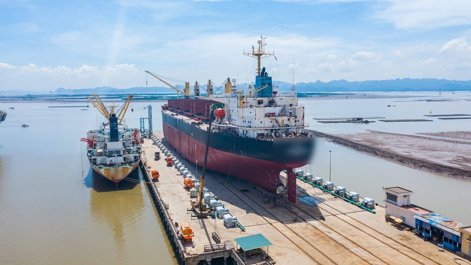 Two bulk carriers alongside a shipyard quay