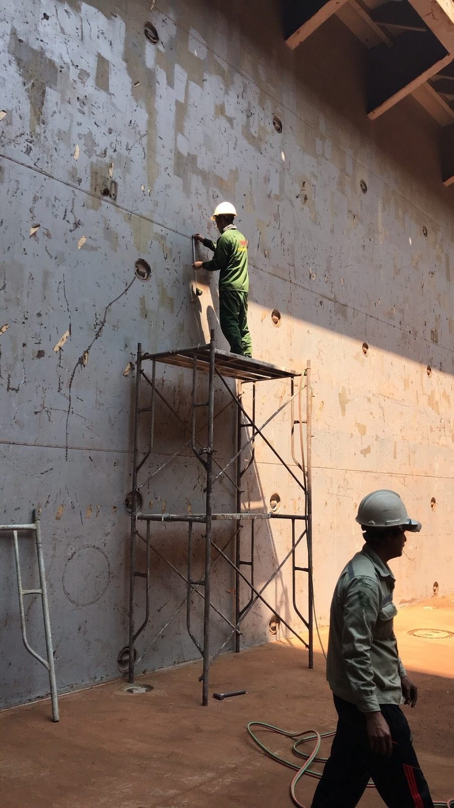 Giàn giáo và đội sửa chữa tại vách hầm hàng