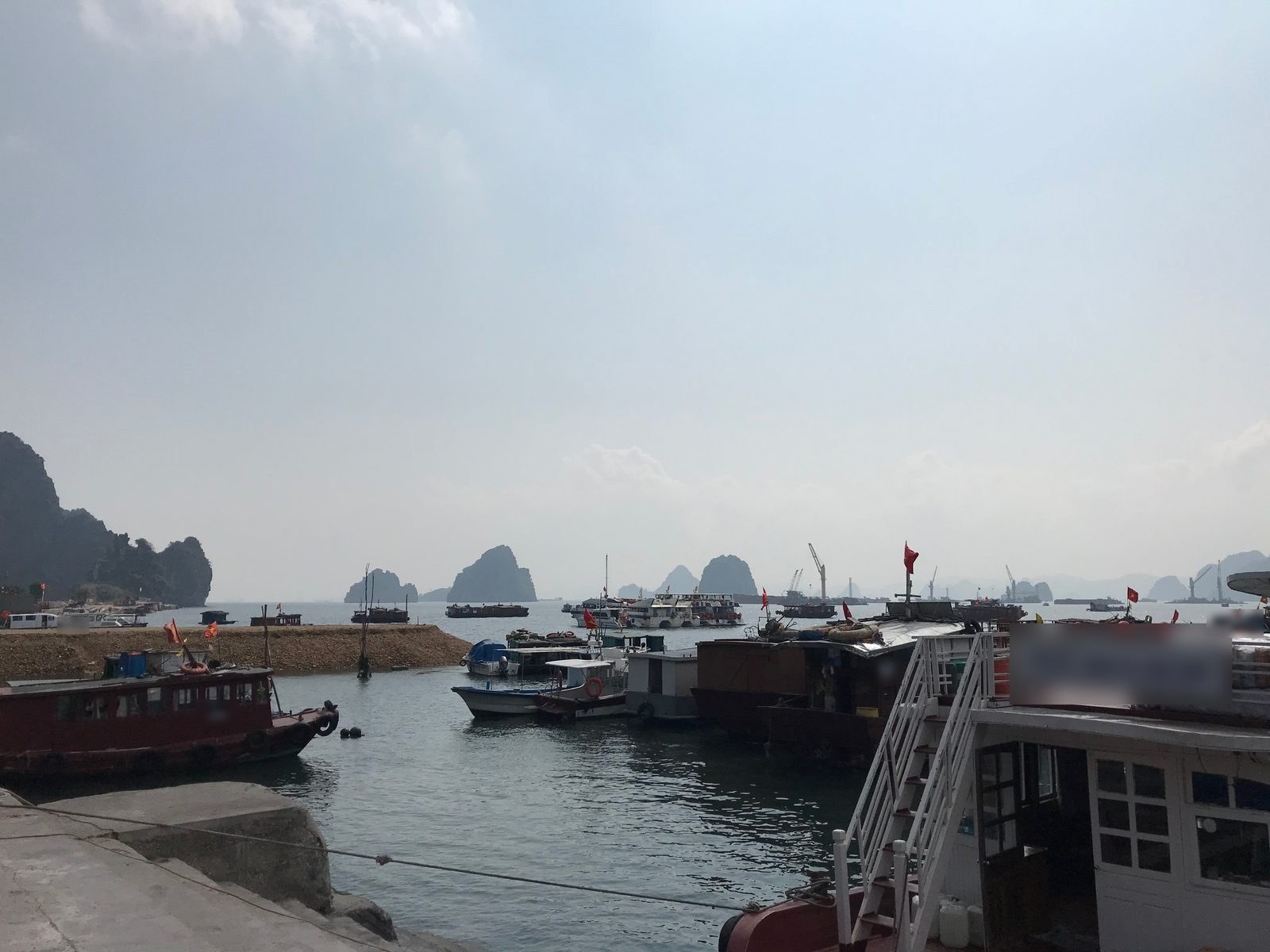 Small vessels moored in Cam Pha with limestone hills behind