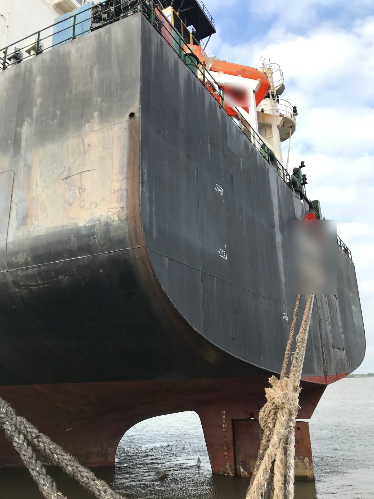 Stern and mooring lines of a commercial vessel alongside