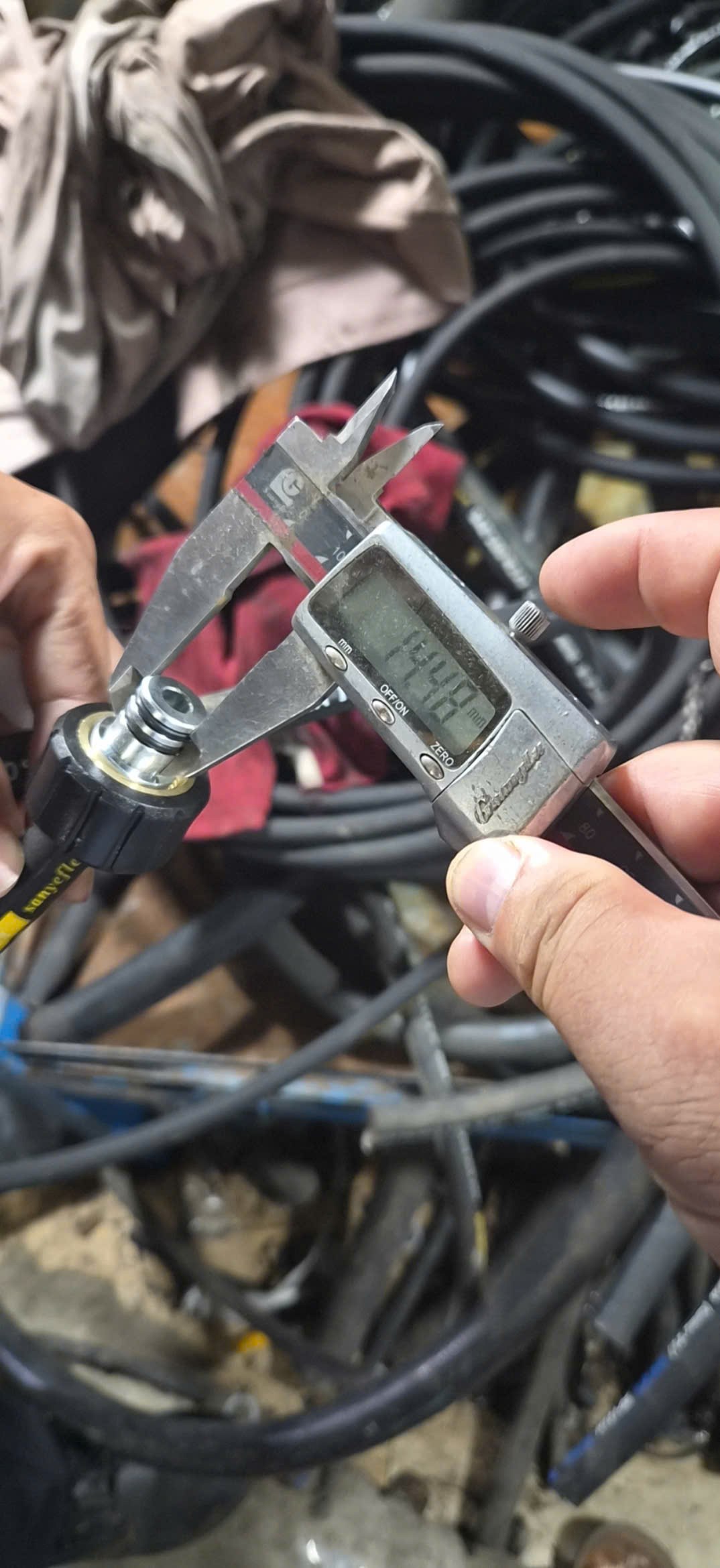 Digital caliper measuring a high-pressure hose coupling