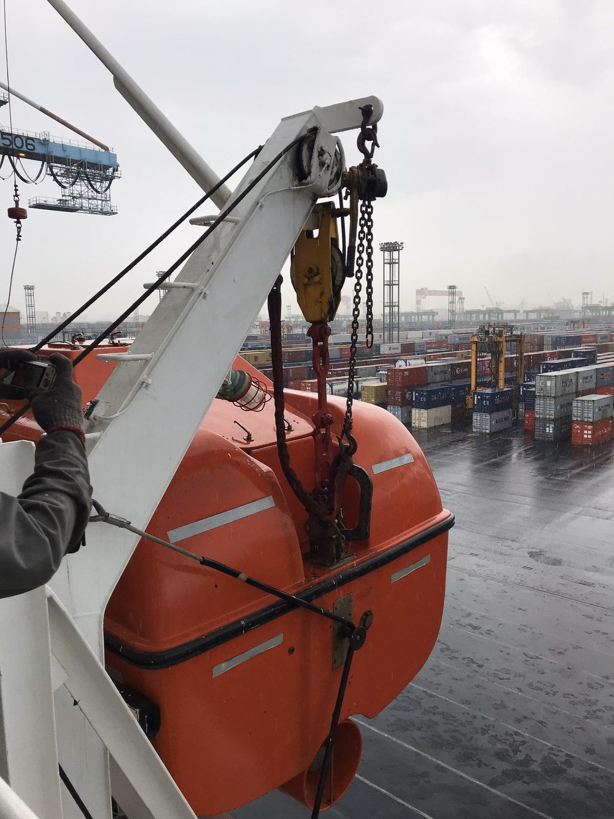 Lifeboat on its davit at a container terminal