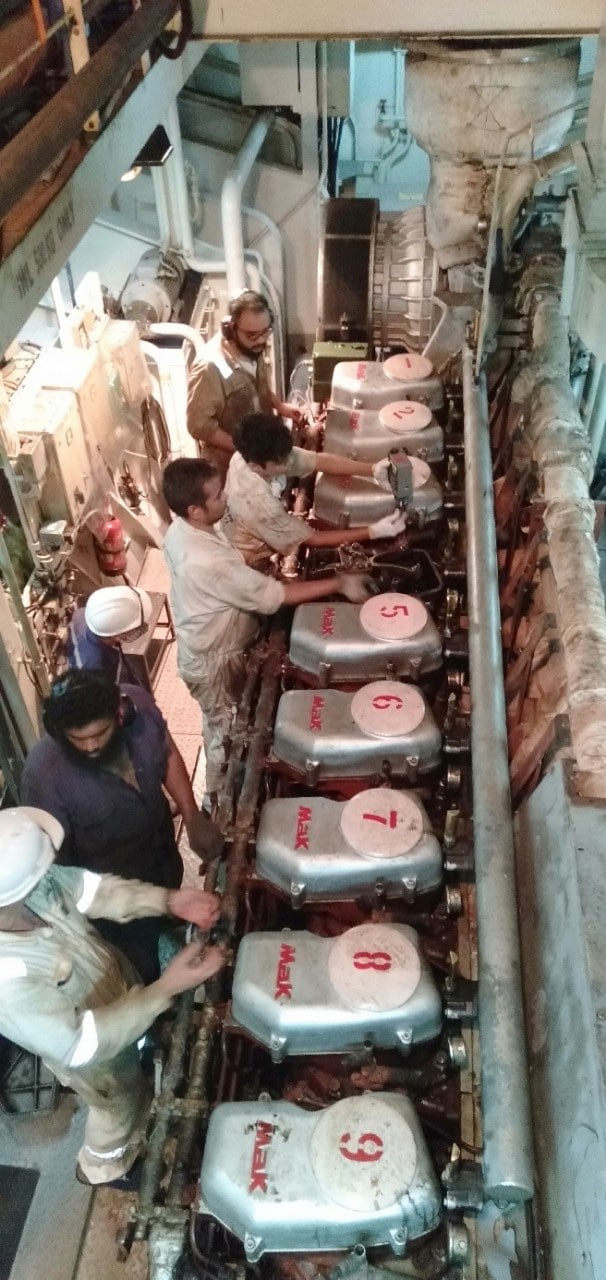 Engine room team overhauling main engine cylinder units
