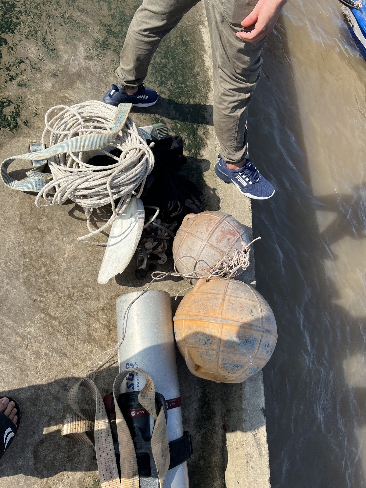 Marker buoys, ropes, lifting slings and a diving cylinder prepared on the jetty