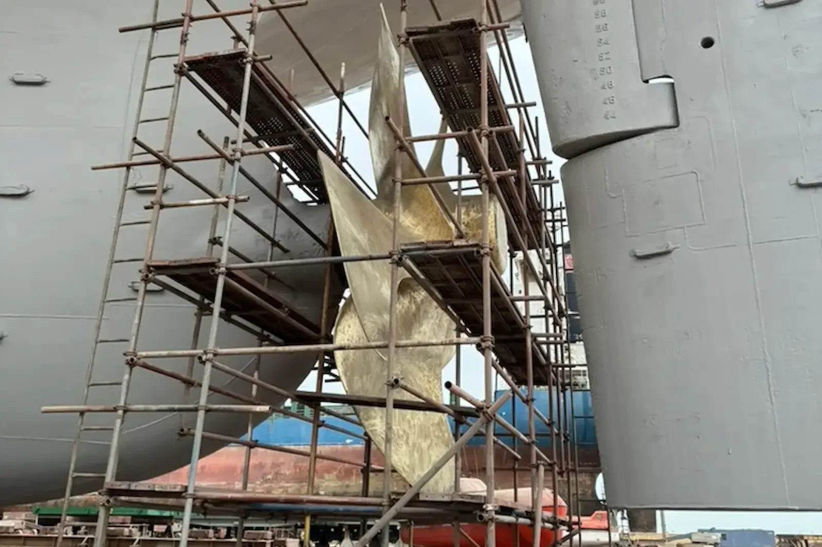 Propeller and rudder under scaffolding in dry dock