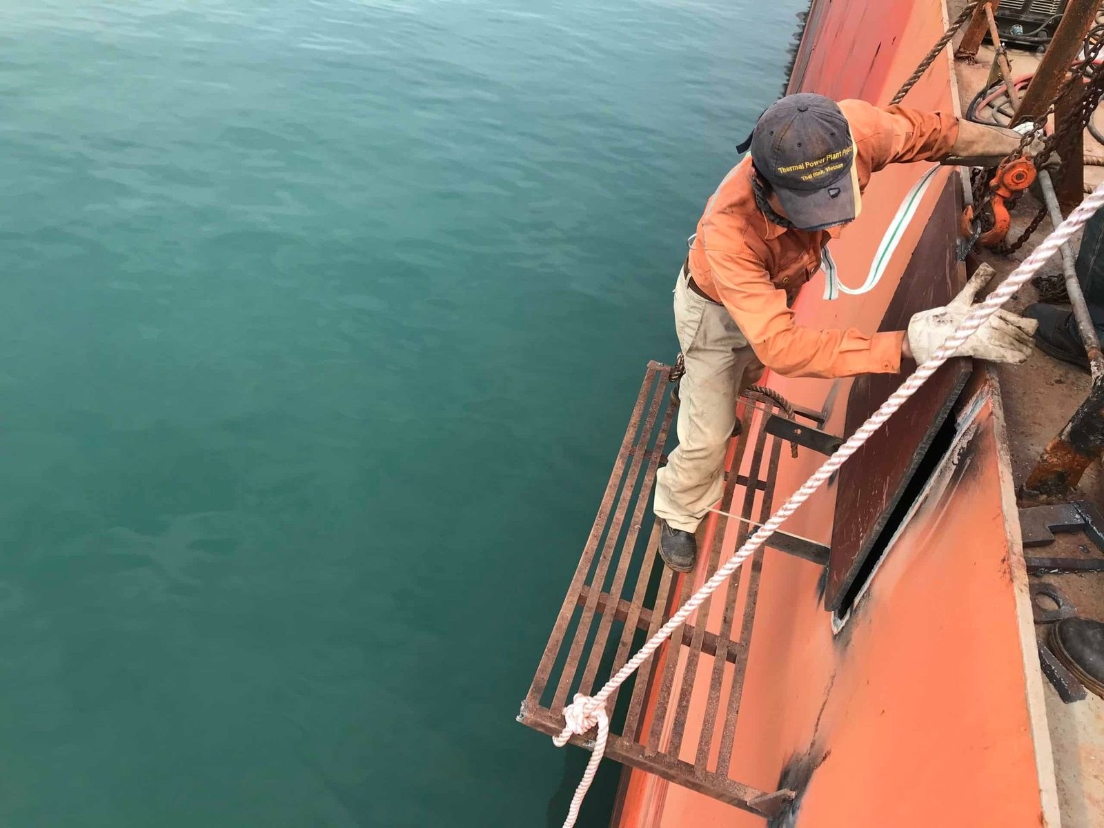 Repair crew working at the ship side at anchorage