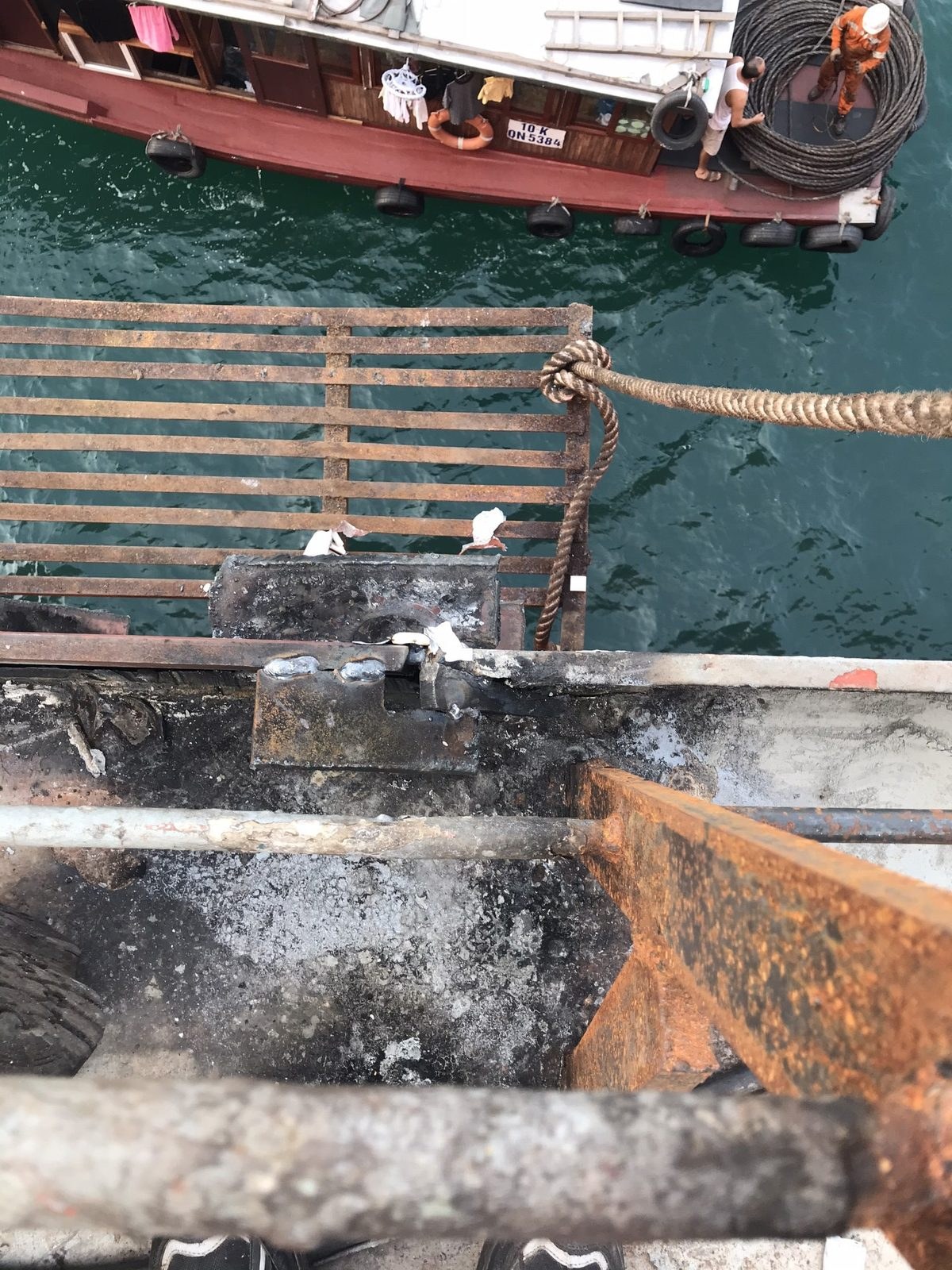 Ship-side repair seen from the deck with a boat alongside