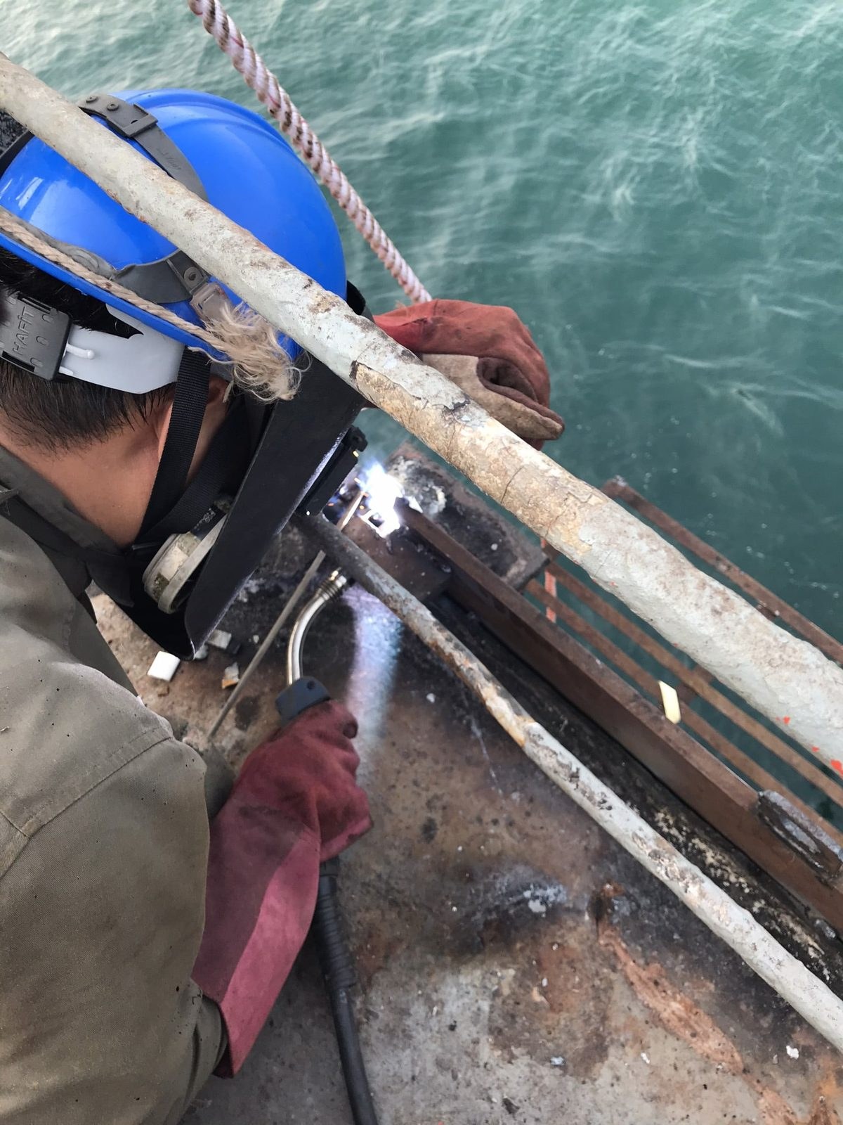 Welding on the ship side from a stage