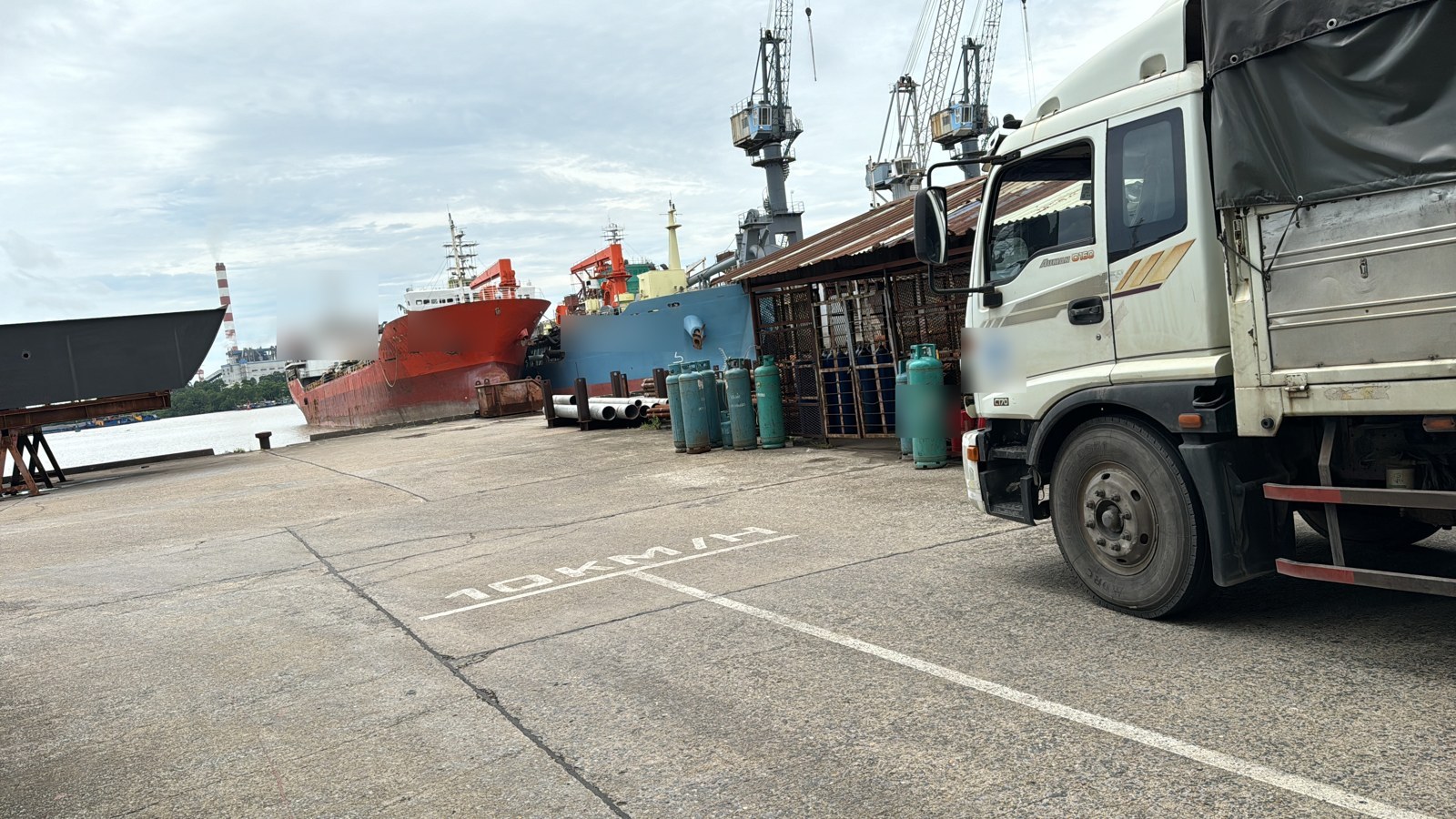 Delivery truck on the quay beside vessels at the berth.