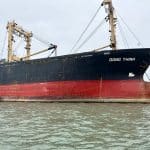 Sister ships Dong An and Dong Thinh alongside in Vietnam prior to paired delivery on 20 December 2024; derrick booms rigged for rice loading.