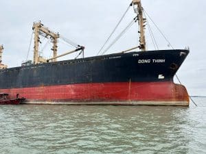 Sister ships Dong An and Dong Thinh alongside in Vietnam prior to paired delivery on 20 December 2024; derrick booms rigged for rice loading.