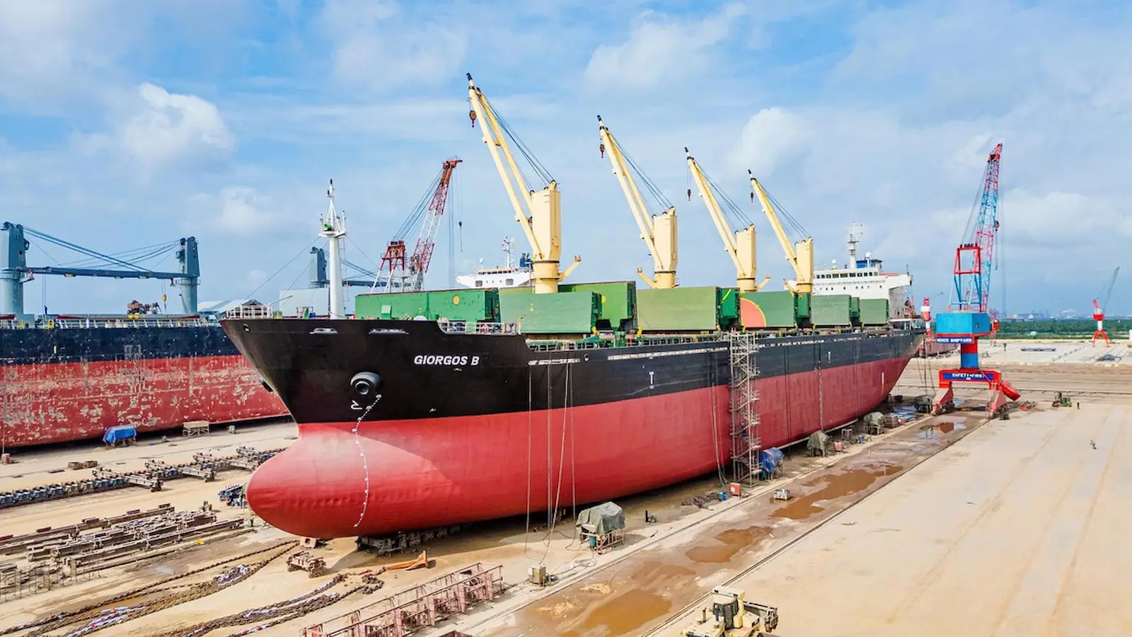 Vessel inside a drydock basin in Vietnam with yard crane, dock blocks, hull repair, steel renewal, machinery service and class survey work areas